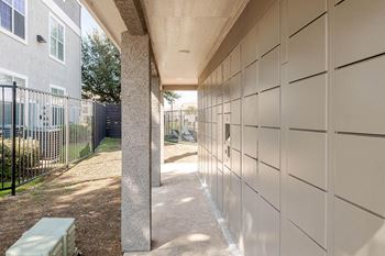 A walkway leading to a building with a fence and a bench